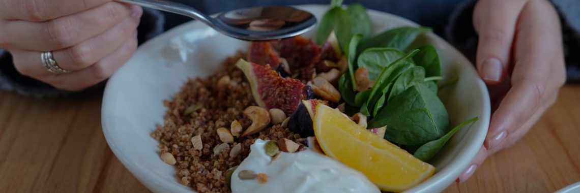 A vibrant brunch bowl with fruit, greens, and nuts for a nutritious meal.